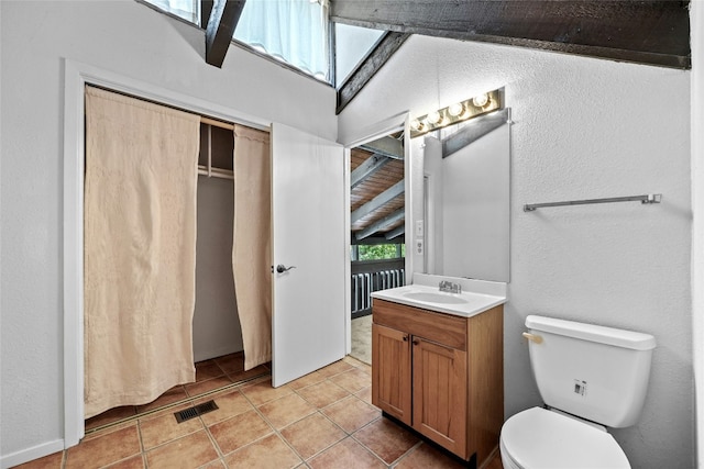 bathroom with tile patterned flooring, vanity, and toilet