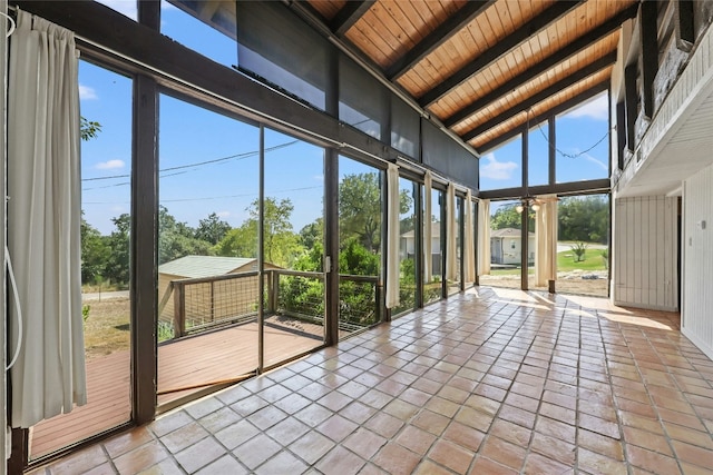 unfurnished sunroom featuring lofted ceiling with beams and wooden ceiling