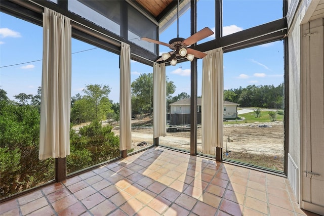 unfurnished sunroom with ceiling fan