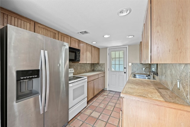 kitchen featuring white electric range, sink, stainless steel refrigerator with ice dispenser, decorative backsplash, and light tile patterned floors