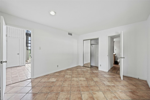 unfurnished bedroom featuring a closet and light tile patterned floors