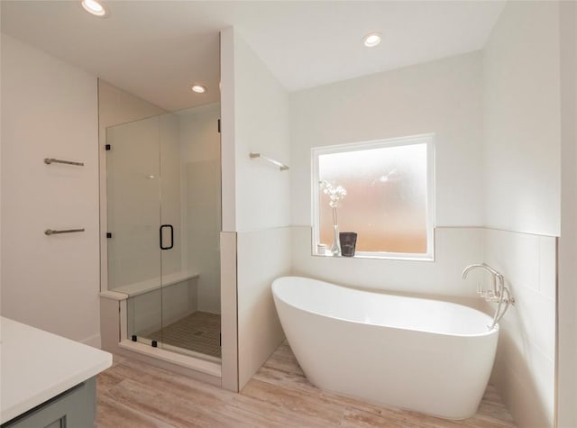 bathroom with vanity, separate shower and tub, and wood-type flooring