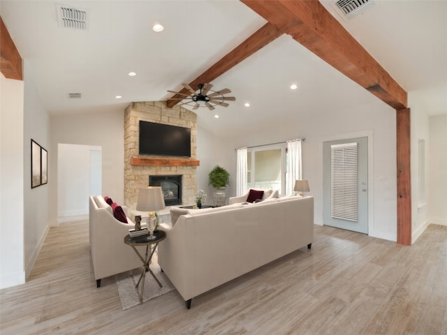 living room with vaulted ceiling with beams, ceiling fan, a fireplace, and light wood-type flooring