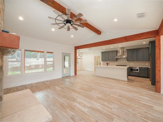 unfurnished living room featuring lofted ceiling with beams, light hardwood / wood-style floors, ceiling fan, and sink