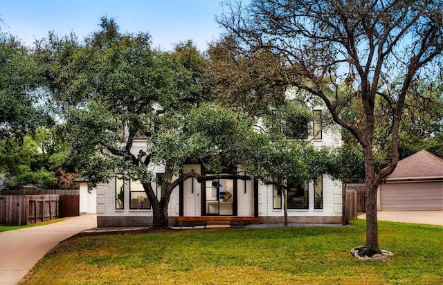 view of property hidden behind natural elements featuring a front lawn