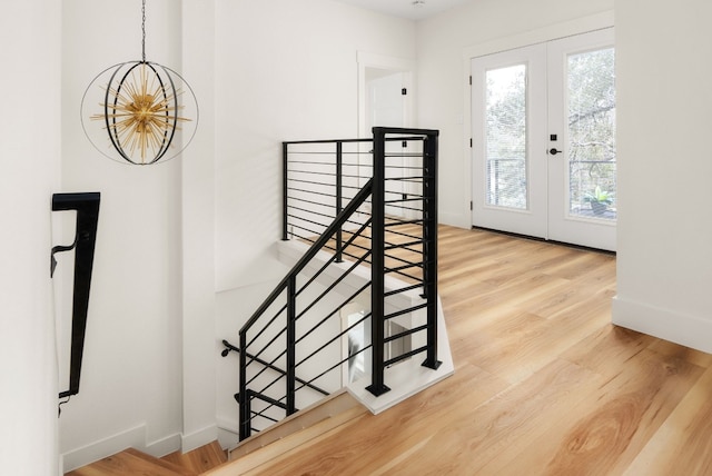 stairs with french doors and wood-type flooring