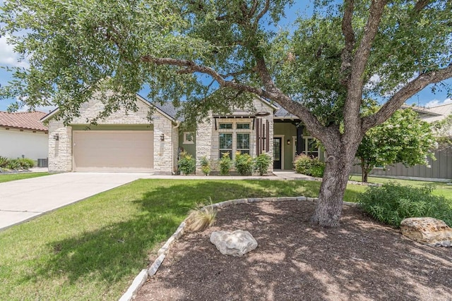 view of front of house with a front lawn, concrete driveway, central AC unit, a garage, and stone siding