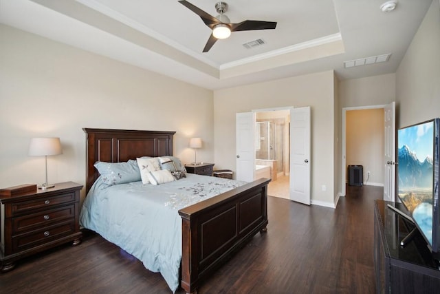 bedroom with connected bathroom, dark hardwood / wood-style floors, a raised ceiling, and ceiling fan