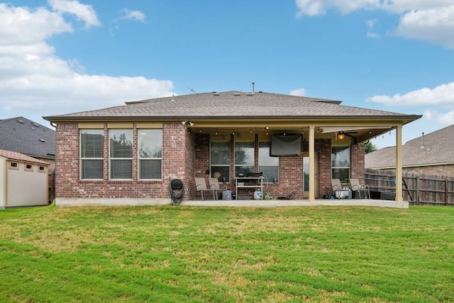 back of property with a lawn, a patio area, and ceiling fan