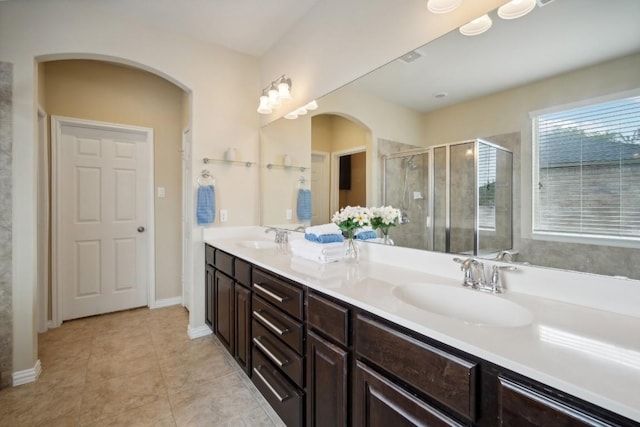 bathroom with tile patterned flooring, vanity, and walk in shower