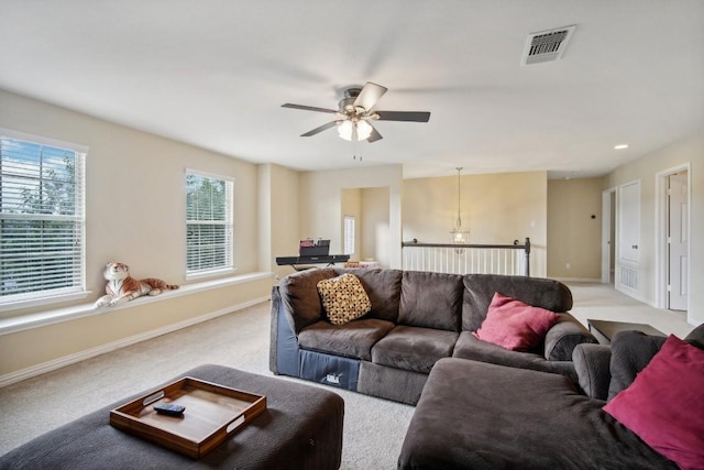 carpeted living room with ceiling fan