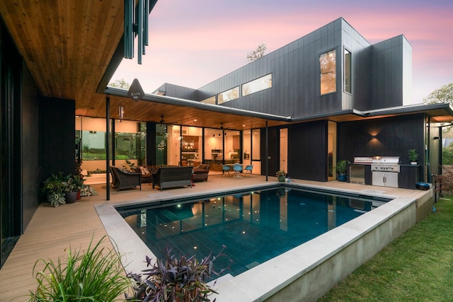 back house at dusk with a patio area and outdoor lounge area