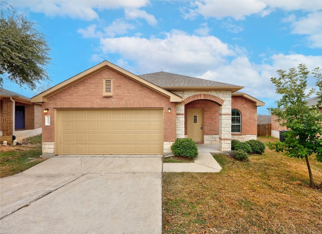 single story home featuring a garage and a front yard