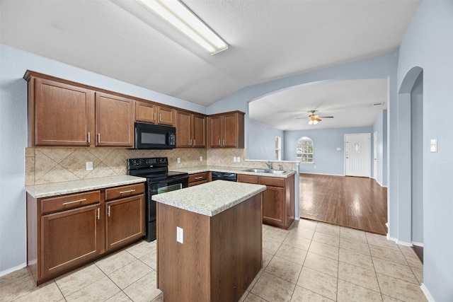 kitchen featuring lofted ceiling, black appliances, ceiling fan, light tile patterned floors, and kitchen peninsula