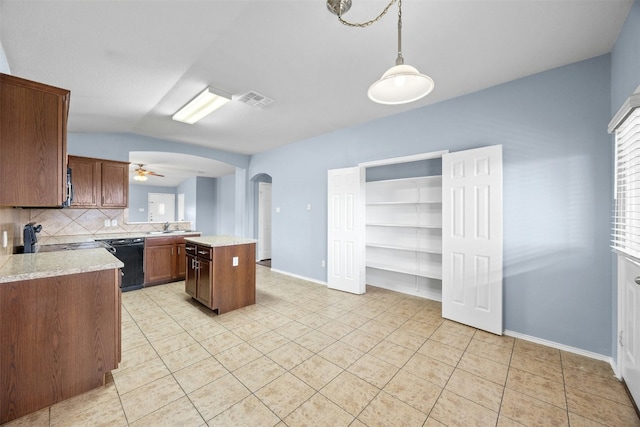 kitchen with dishwasher, hanging light fixtures, backsplash, vaulted ceiling, and a kitchen island