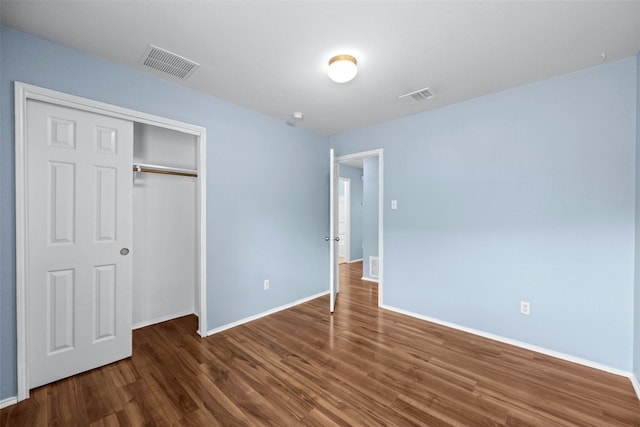 unfurnished bedroom featuring dark hardwood / wood-style flooring and a closet