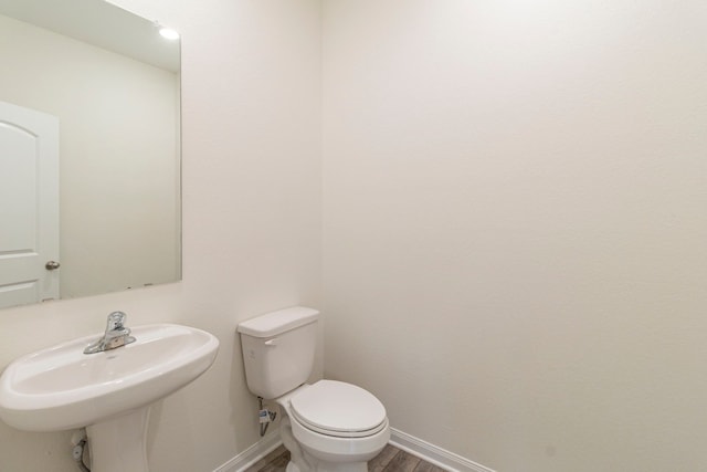 bathroom featuring sink, wood-type flooring, and toilet