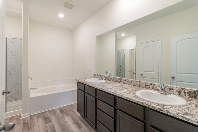 bathroom with hardwood / wood-style floors, vanity, and independent shower and bath