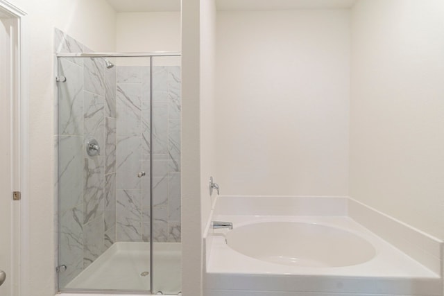 bathroom featuring shower with separate bathtub