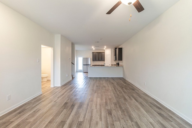 unfurnished living room with ceiling fan and light hardwood / wood-style flooring