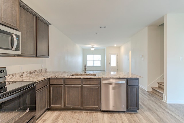 kitchen featuring dark brown cabinetry, ceiling fan, sink, stainless steel appliances, and kitchen peninsula