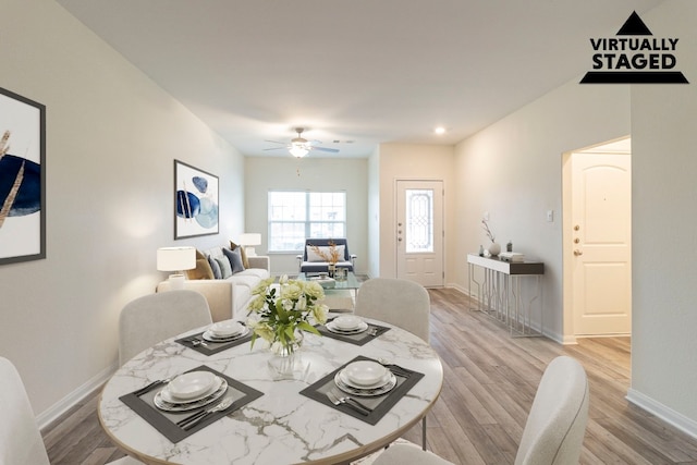 dining area with ceiling fan and light hardwood / wood-style floors