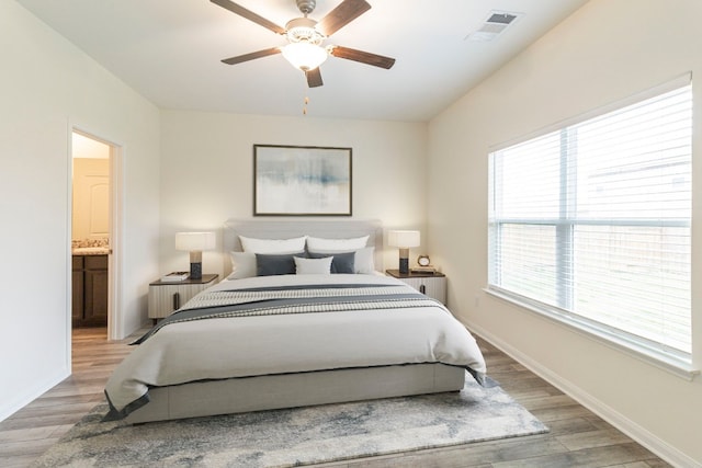 bedroom with ceiling fan, light hardwood / wood-style floors, and ensuite bathroom