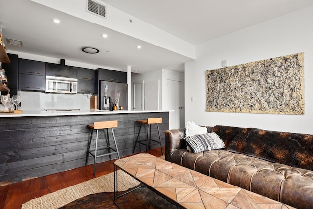 living room with dark hardwood / wood-style flooring and bar area