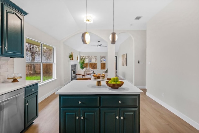 kitchen featuring tasteful backsplash, ceiling fan, decorative light fixtures, dishwasher, and a center island