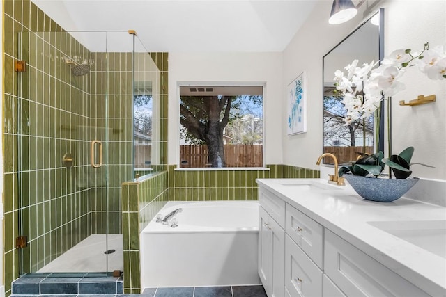 bathroom featuring plus walk in shower, vanity, and tile patterned flooring