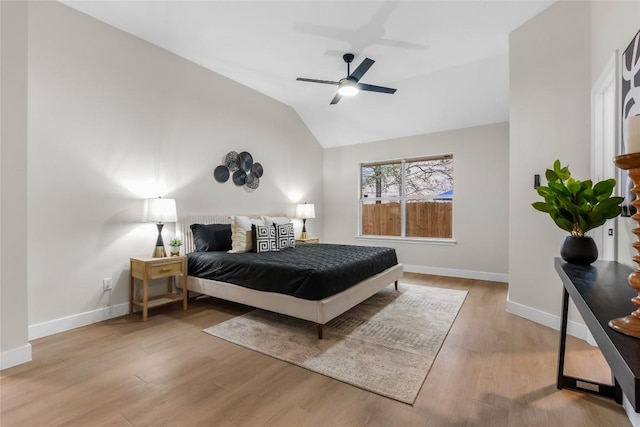 bedroom with ceiling fan, light hardwood / wood-style flooring, and vaulted ceiling