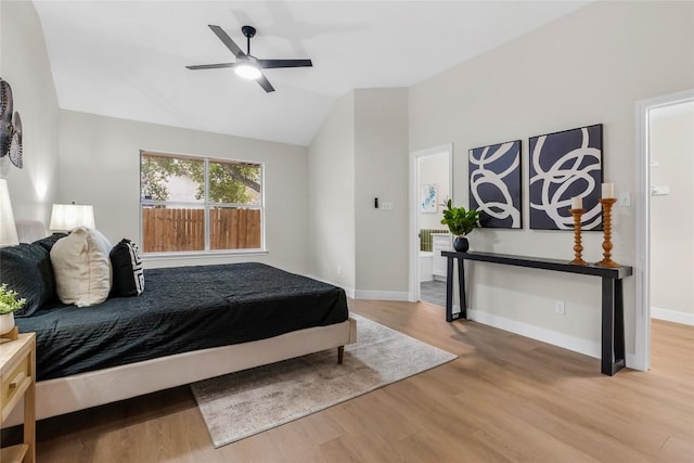 bedroom with ceiling fan, wood-type flooring, and lofted ceiling