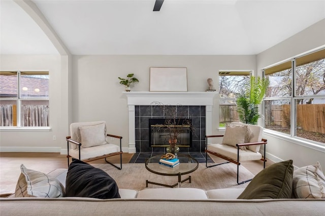 living room with light wood-type flooring and a tiled fireplace