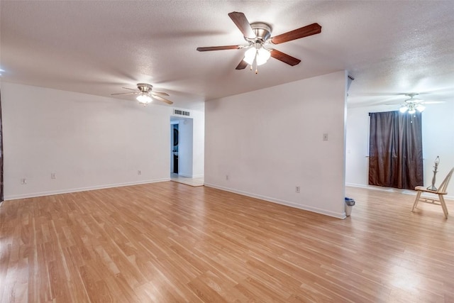 unfurnished room with a textured ceiling and light hardwood / wood-style flooring