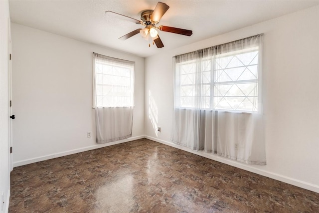 unfurnished room featuring ceiling fan and a wealth of natural light