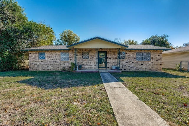 ranch-style home featuring covered porch and a front lawn