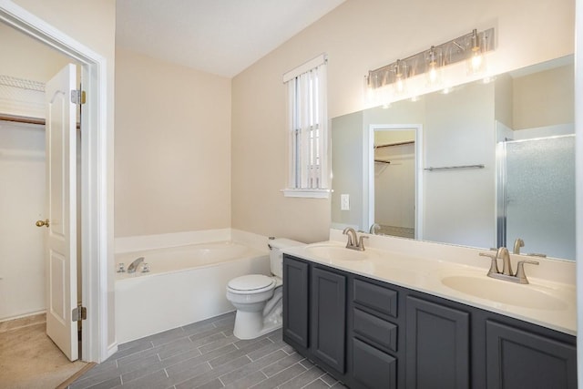 bathroom featuring vanity, toilet, and a tub to relax in