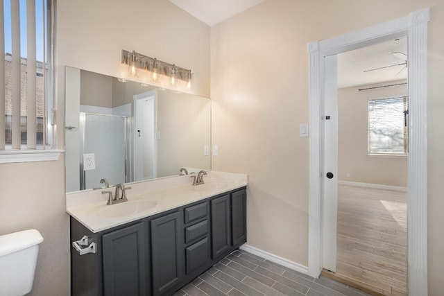 bathroom with vanity, toilet, and a shower with door