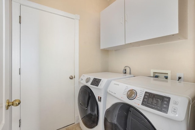 washroom featuring washer and dryer, light tile patterned floors, and cabinets