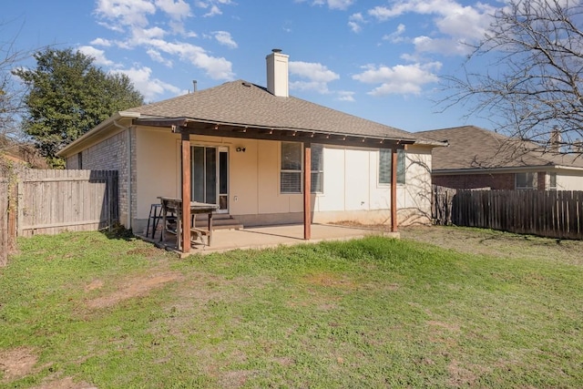 rear view of property with a lawn and a patio area