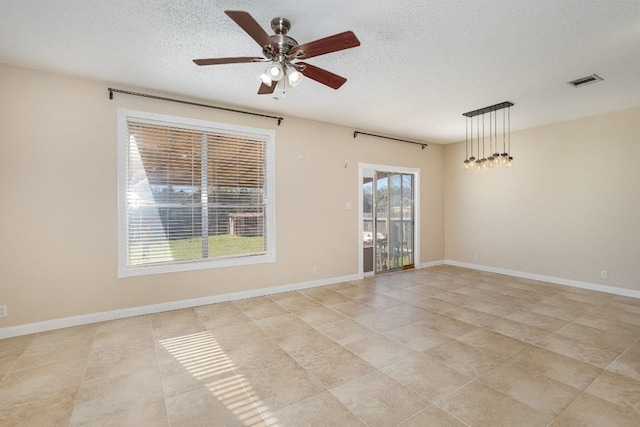 unfurnished room with ceiling fan and a textured ceiling