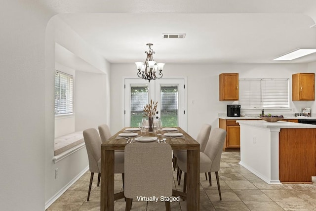 dining room featuring a chandelier, a skylight, and sink