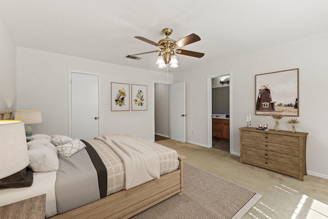 carpeted bedroom with ceiling fan and ensuite bath