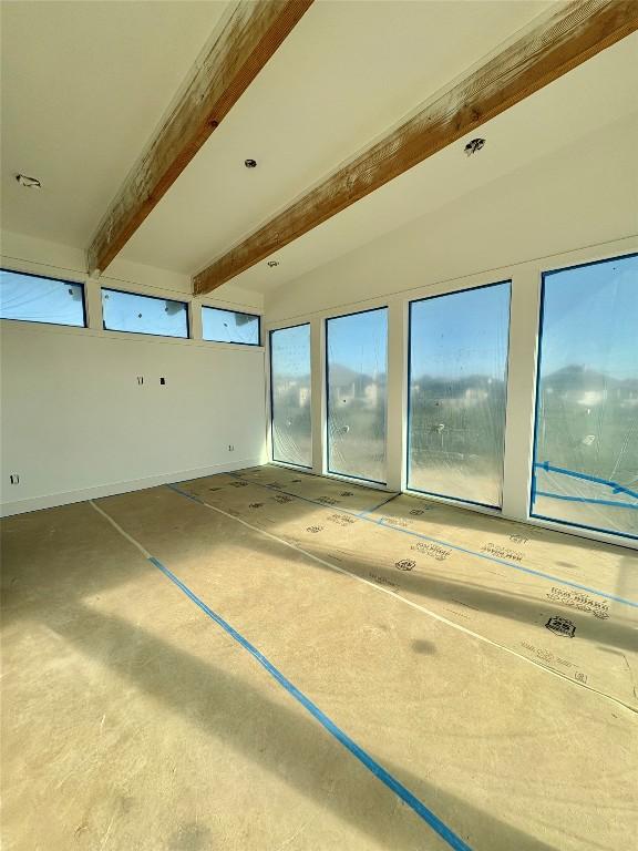 unfurnished room featuring beam ceiling