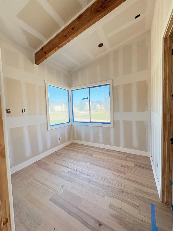 unfurnished room featuring beam ceiling and light hardwood / wood-style flooring