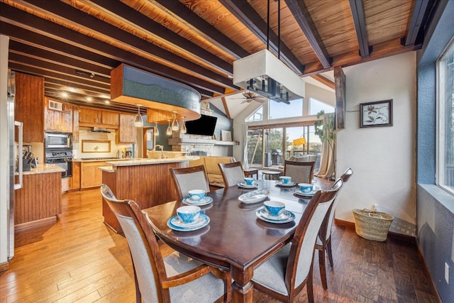 dining room with beam ceiling, light hardwood / wood-style floors, ceiling fan, and wood ceiling