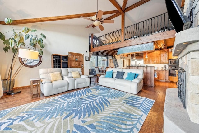 living room featuring hardwood / wood-style flooring, ceiling fan, beam ceiling, and high vaulted ceiling