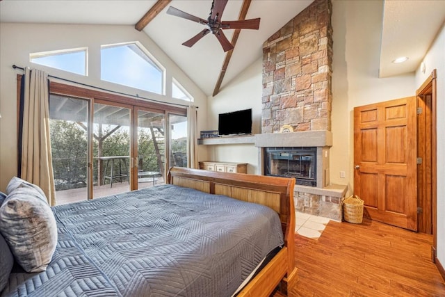 bedroom with access to outside, ceiling fan, light wood-type flooring, a fireplace, and beamed ceiling