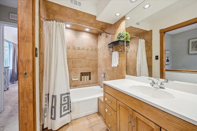 bathroom with tile patterned floors, shower / bathtub combination with curtain, and vanity