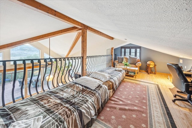 interior space with hardwood / wood-style floors, lofted ceiling with beams, and a textured ceiling